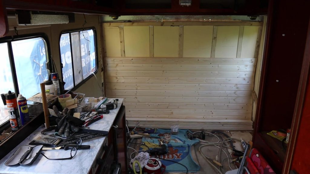 Mit Holzpanele wird die Rückwand im Ford Transit Wohnmobil verkleidet